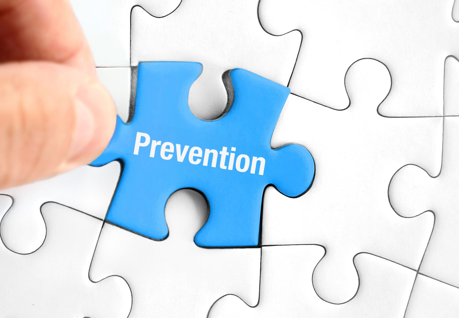 Blue Puzzle Piece with “Prevention” in Hand – Prevention in Various Areas